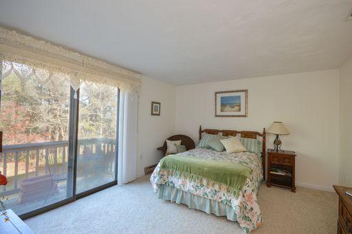 195 Falmouth Road, Unit 14C Mashpee, MA 02649 - Photo 19 of 27 a bedroom with a bed and a large window