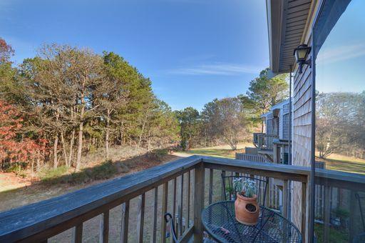195 Falmouth Road, Unit 14C Mashpee, MA 02649 - Photo 20 of 27 a balcony with wooden floor and outdoor seating