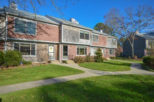 195 Falmouth Road, Unit 14C Mashpee, MA 02649 - Photo 2 of 27 a front view of a house with a yard