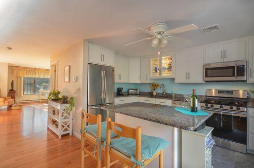 195 Falmouth Road, Unit 14C Mashpee, MA 02649 - Photo 9 of 27 a kitchen with stainless steel appliances granite countertop a stove refrigerator and a sink