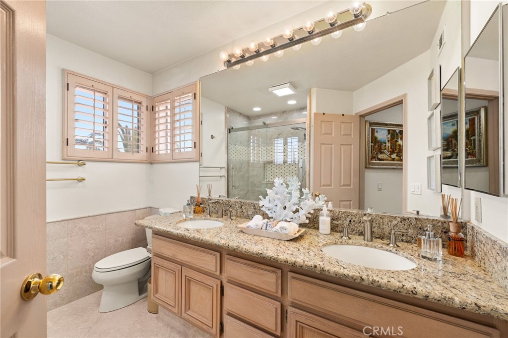 950 Chantel Drive Corona, CA 92879 - Photo 17 of 27 a bathroom with a granite countertop sink a toilet and a mirror