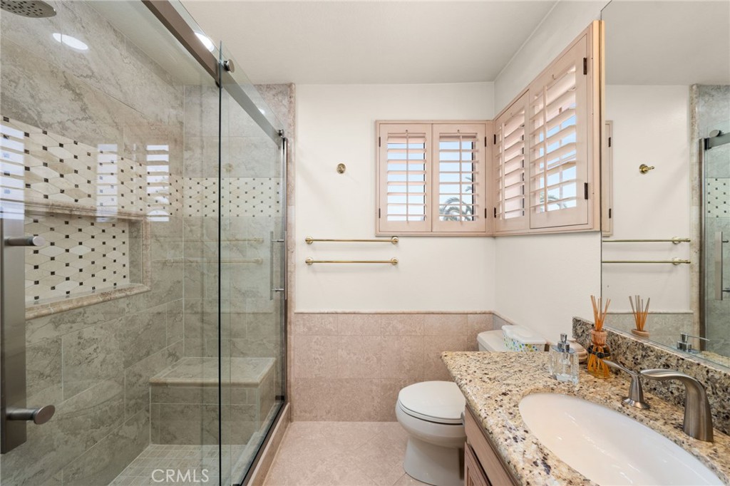 950 Chantel Drive Corona, CA 92879 - Photo 18 of 27 a bathroom with a granite countertop sink toilet a mirror and shower