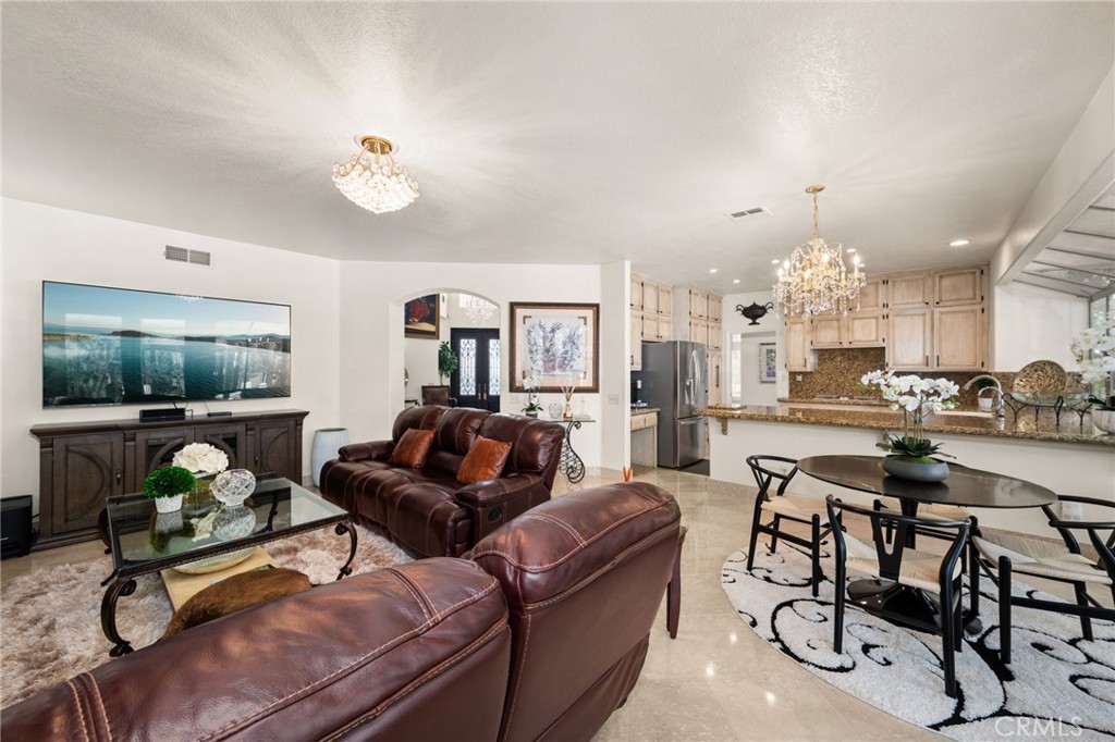 950 Chantel Drive Corona, CA 92879 - Photo 9 of 27 a living room with furniture a chandelier and a floor to ceiling window