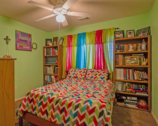 a bedroom with a bed and a book shelf