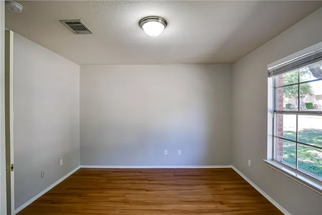 wooden floor in an empty room with a window