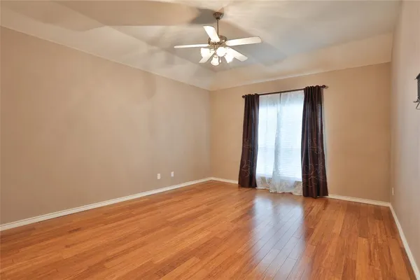 a view of an empty room with wooden floor