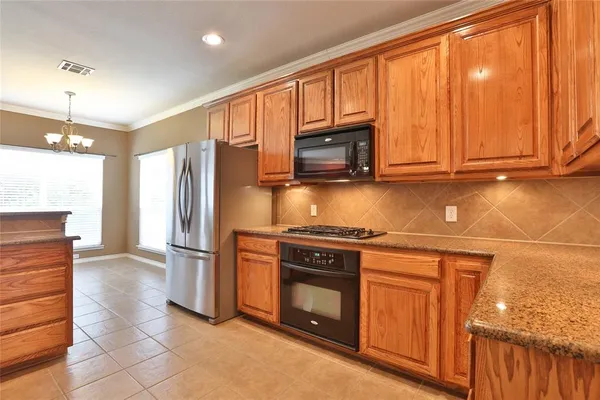 a kitchen with stainless steel appliances granite countertop a stove a refrigerator and a microwave