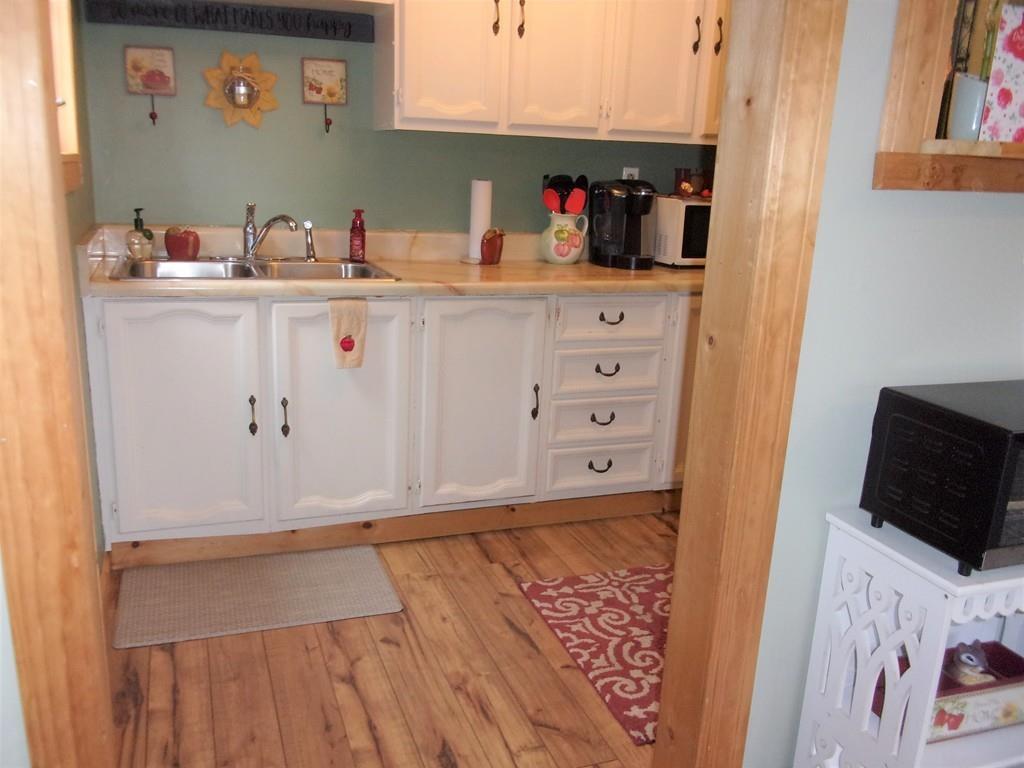 158 Osborne Road Ware, MA 01082 - Photo 14 of 31 a kitchen with white cabinets a sink and wooden floor