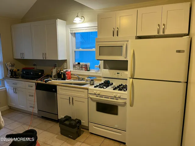 a kitchen with a refrigerator sink stove and cabinets