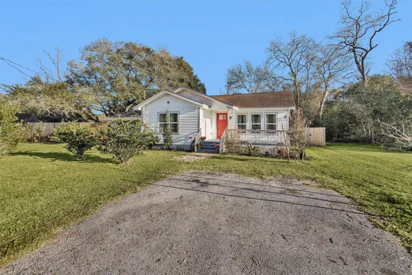 a front view of a house with a yard and trees