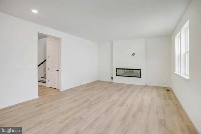 a view of empty room with wooden floor and window