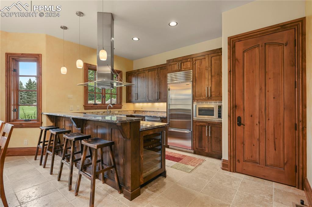 22 Crossland Road Colorado Springs, CO 80906 - Photo 43 of 49 a kitchen with kitchen island granite countertop wooden cabinets and counter space