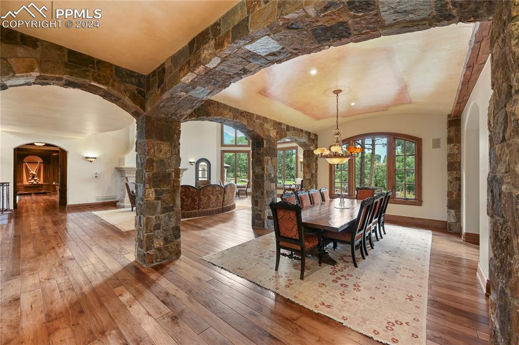 22 Crossland Road Colorado Springs, CO 80906 - Photo 7 of 49 a dining room with wooden floor a chandelier a glass table and chairs