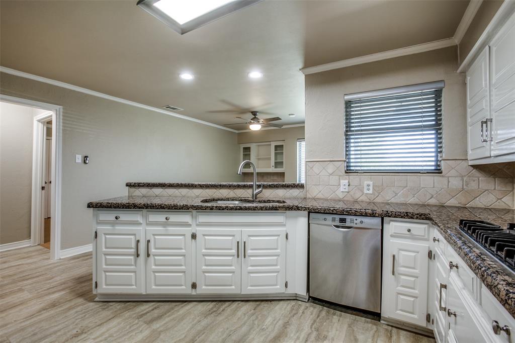 2700 Quail Ridge Drive Carrollton, TX 75006 - Photo 9 of 30 Kitchen with stainless steel appliances, a peninsula, ornamental molding, white cabinets, and recessed lighting