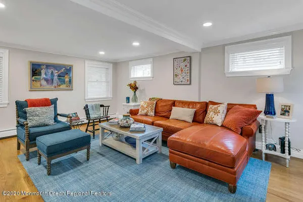 a living room with furniture a couch and two windows