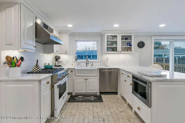 a kitchen with a sink stove and white cabinets