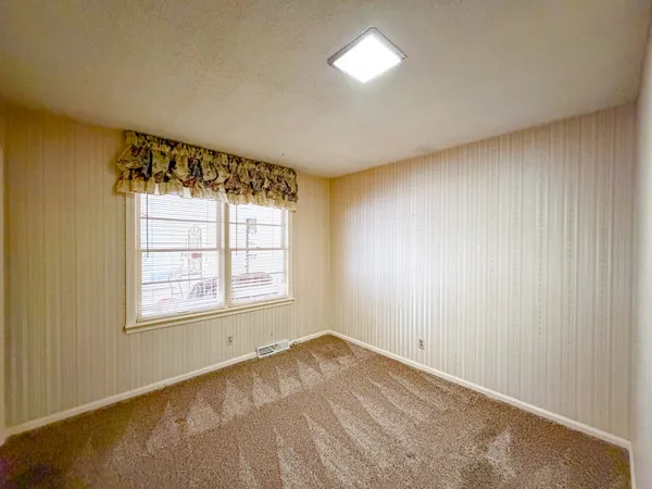 an empty room with wooden floor and cabinet
