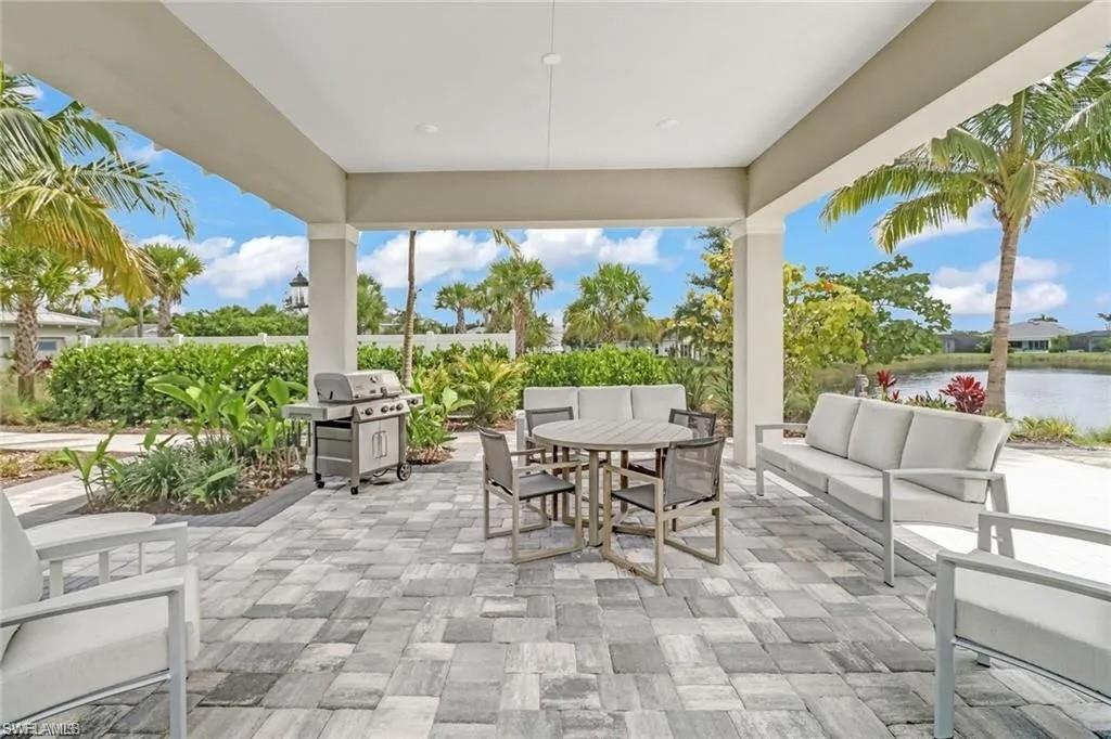 9175 Cayman Drive Naples, FL 34114 - Photo 23 of 31 a living room with patio furniture and a floor to ceiling window