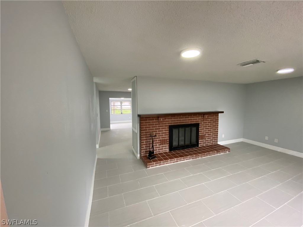 2316 Lotus Road Fort Myers, FL 33905 - Photo 8 of 35 a view of a livingroom with wooden floor and a fireplace