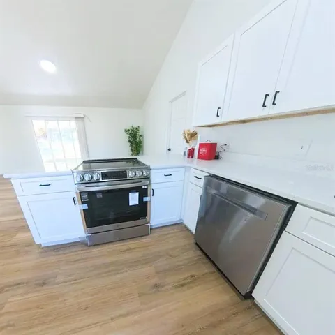 a kitchen with stainless steel appliances a stove microwave and cabinets