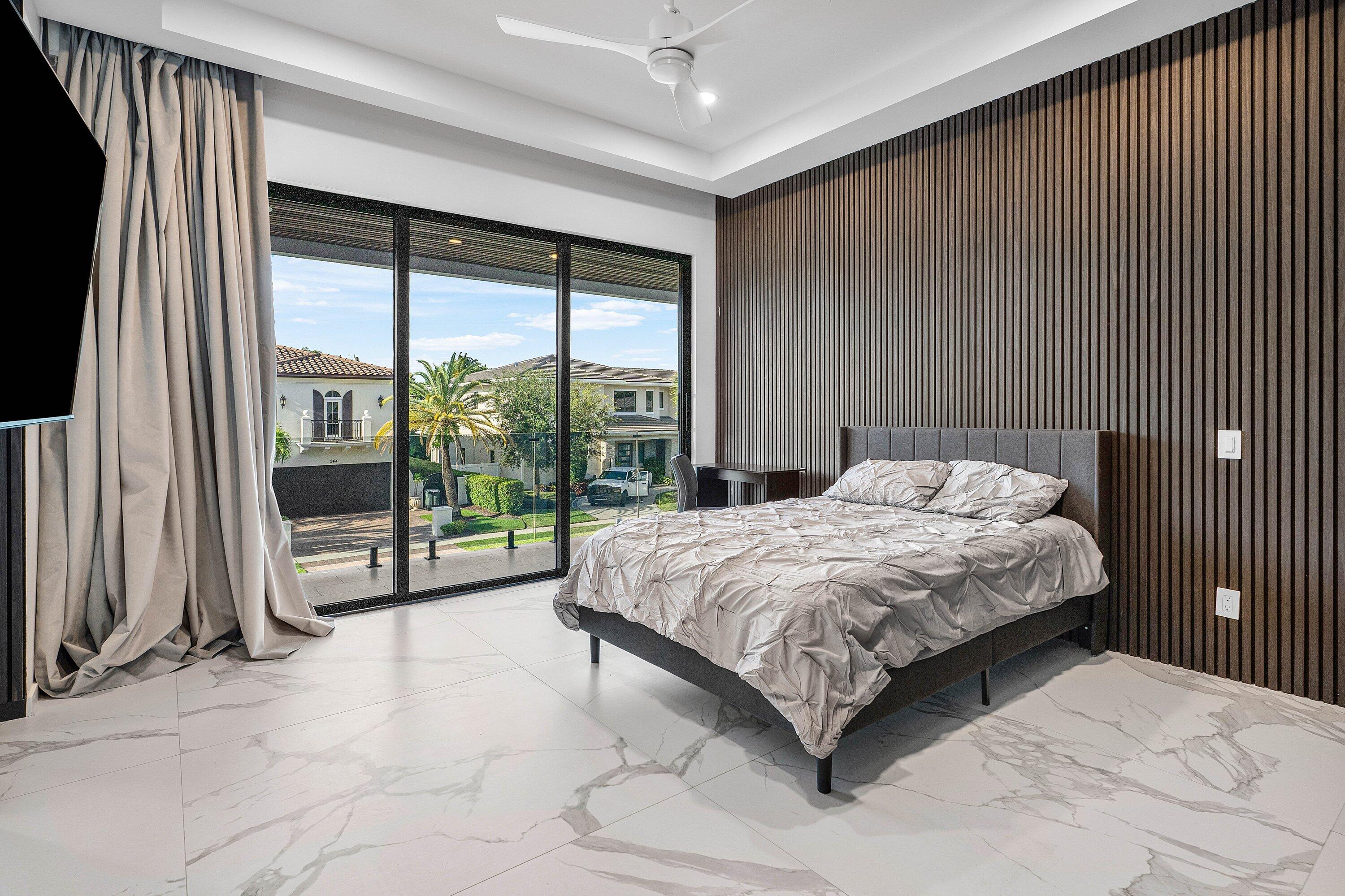 245 Northeast 6th Court Boca Raton, FL 33432 - Photo 20 of 84 a bedroom with a bed and a large window