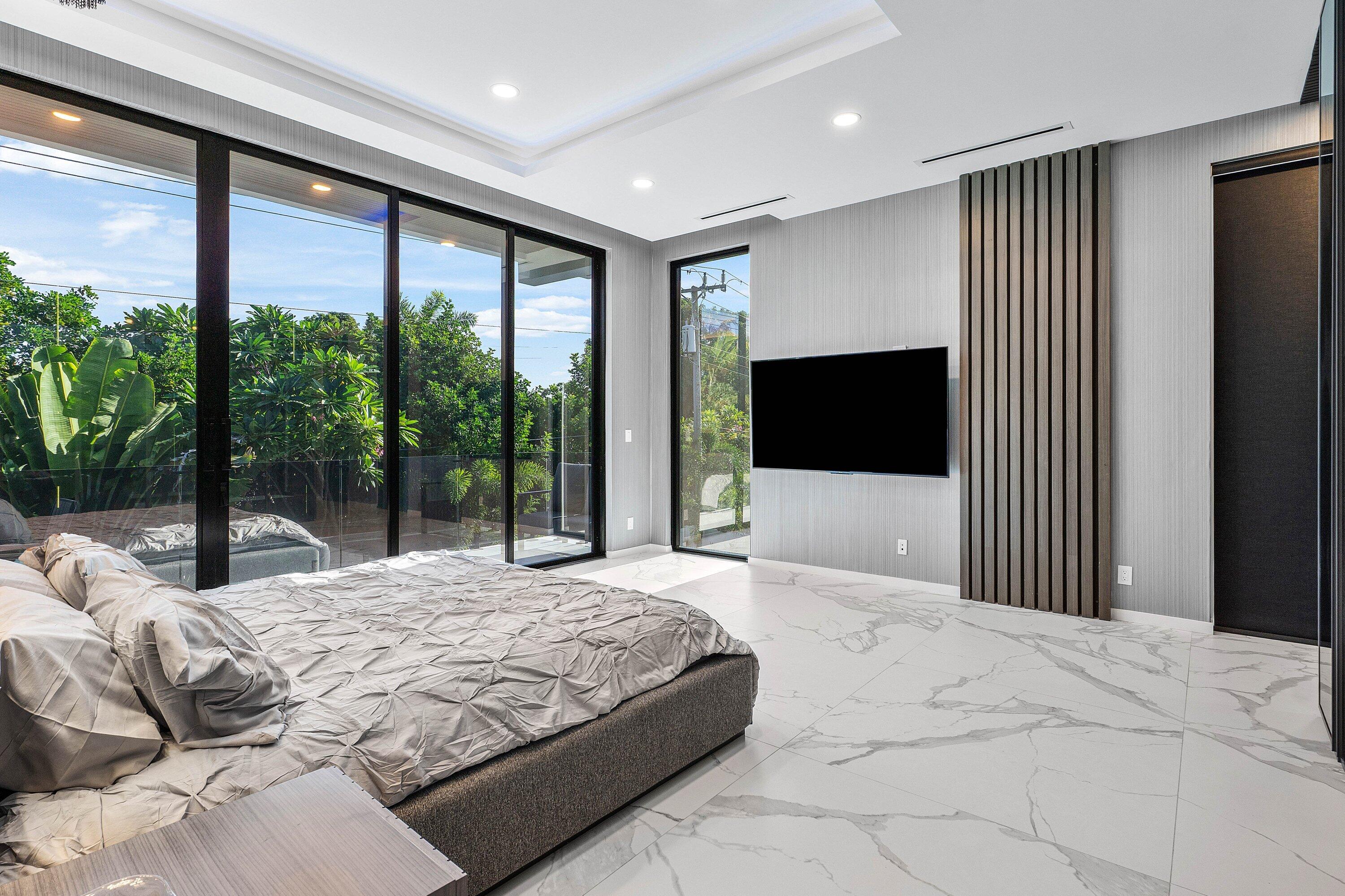 245 Northeast 6th Court Boca Raton, FL 33432 - Photo 23 of 84 a bedroom with a large bed and a flat tv screen