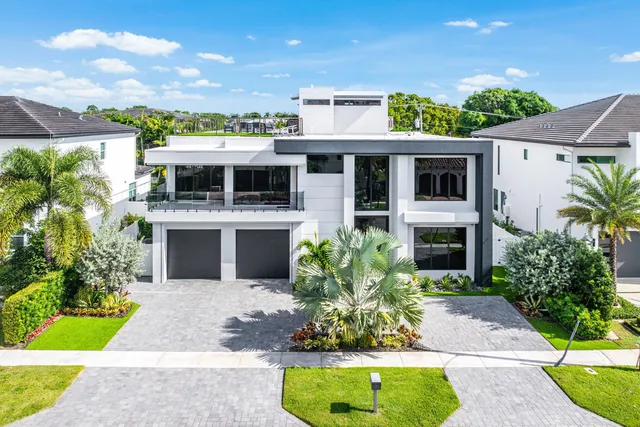 a view of a backyard with table and chairs potted plants and palm trees
