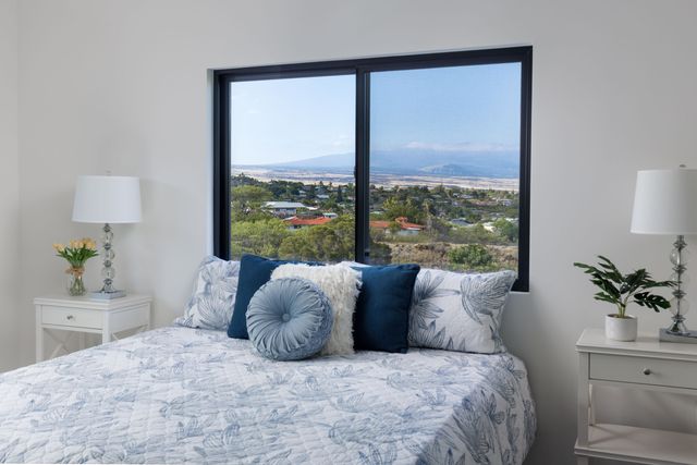 a large bed sitting in a bedroom next to a window