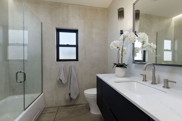 a bathroom with a double vanity sink toilet and shower