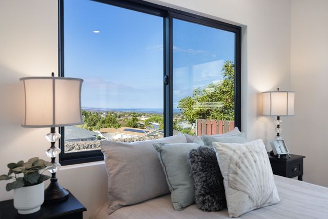a large bed sitting in a bedroom next to a window