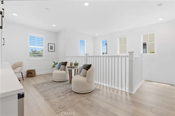 a swimming pool with lawn chairs under an umbrella and palm trees