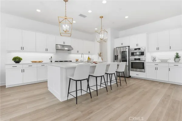 a kitchen with kitchen island granite countertop a sink cabinets and wooden floor