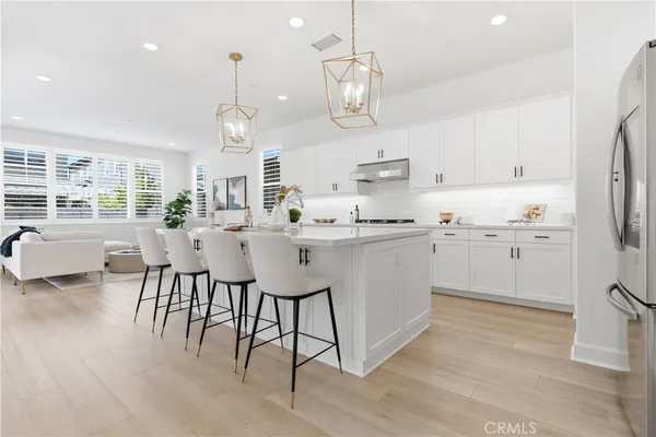 a kitchen with kitchen island granite countertop a sink cabinets and wooden floor