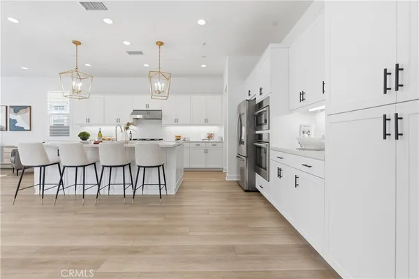 a large kitchen with stainless steel appliances kitchen island granite countertop a refrigerator and a stove top oven