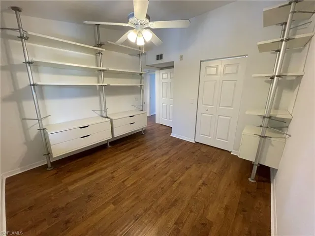 a view of a room with wooden floor and ceiling fan