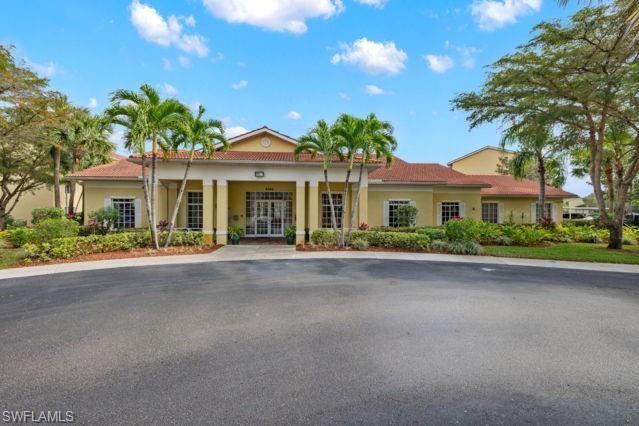 8234 Key Royal Circle, Unit 533 Naples, FL 34119 - Photo 20 of 24 a front view of a house with a yard and garage