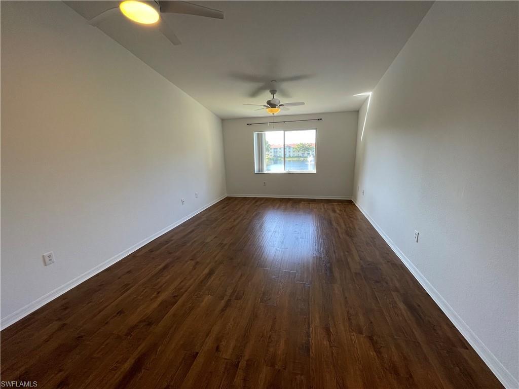 8234 Key Royal Circle, Unit 533 Naples, FL 34119 - Photo 5 of 24 an empty room with wooden floor and windows