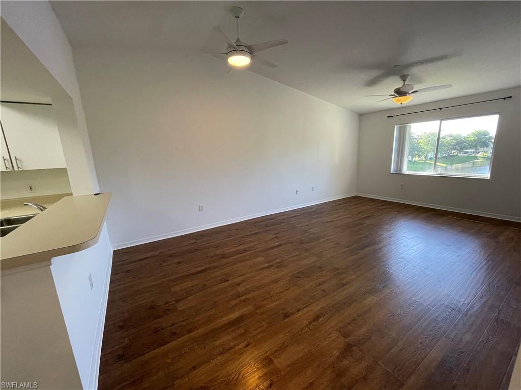 8234 Key Royal Circle, Unit 533 Naples, FL 34119 - Photo 6 of 24 a view of an empty room with wooden floor and a window