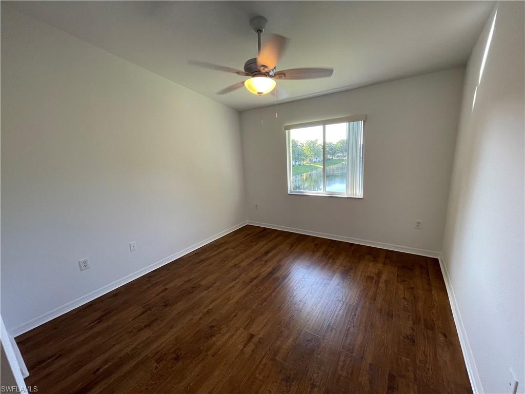 8234 Key Royal Circle, Unit 533 Naples, FL 34119 - Photo 7 of 24 an empty room with wooden floor and windows
