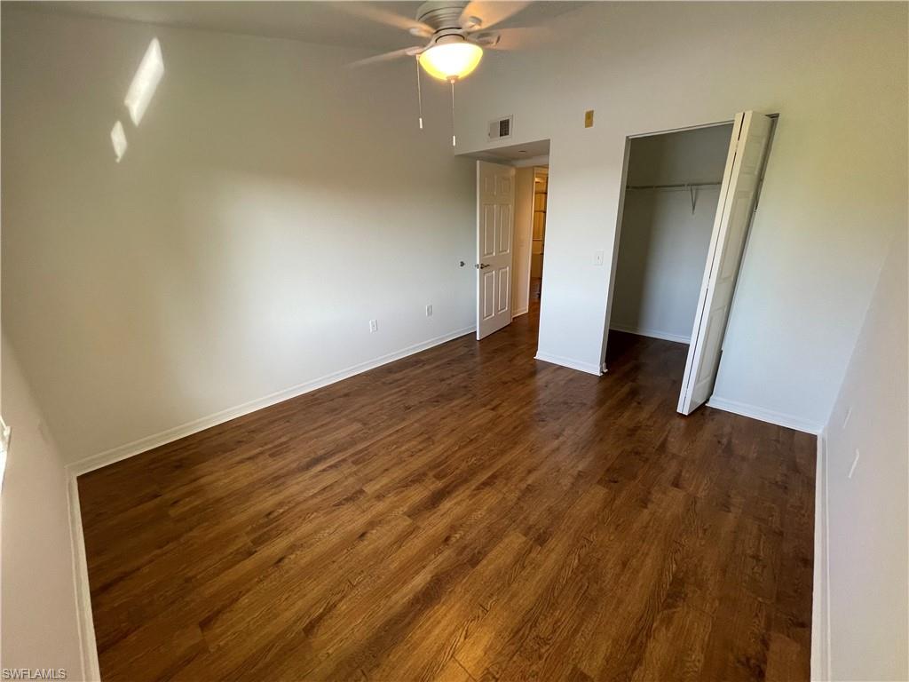 8234 Key Royal Circle, Unit 533 Naples, FL 34119 - Photo 8 of 24 an empty room with wooden floor and bathroom