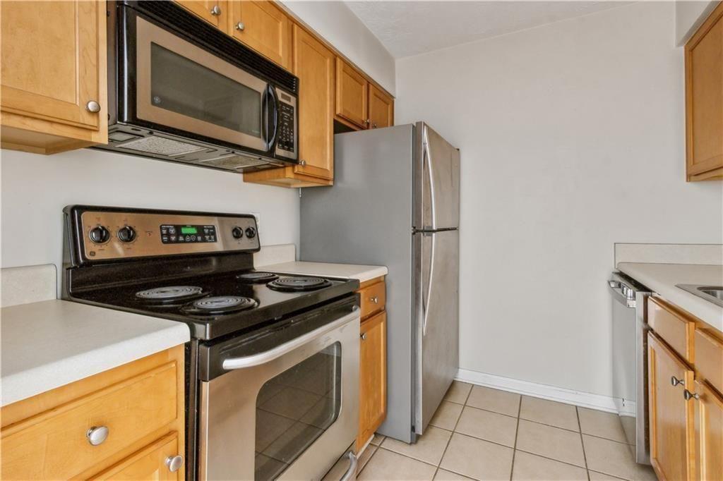 3155 Seven Pines, Unit 303 Atlanta, GA 30339 - Photo 9 of 25 a kitchen with stainless steel appliances granite countertop a stove microwave and refrigerator