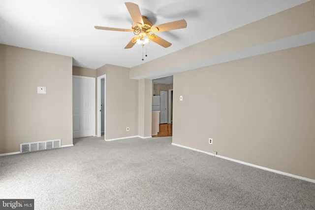 an empty room with chandelier fan
