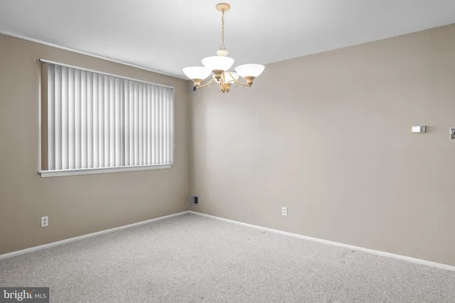 a view of a room with a window and a chandelier fan