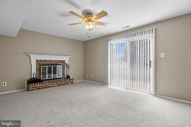 an empty room with a ceiling fan and a window