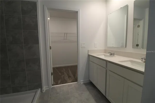 a bathroom with a shower sink and mirror