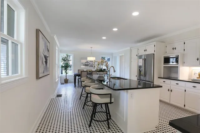 a kitchen with stainless steel appliances kitchen island granite countertop a sink and a refrigerator