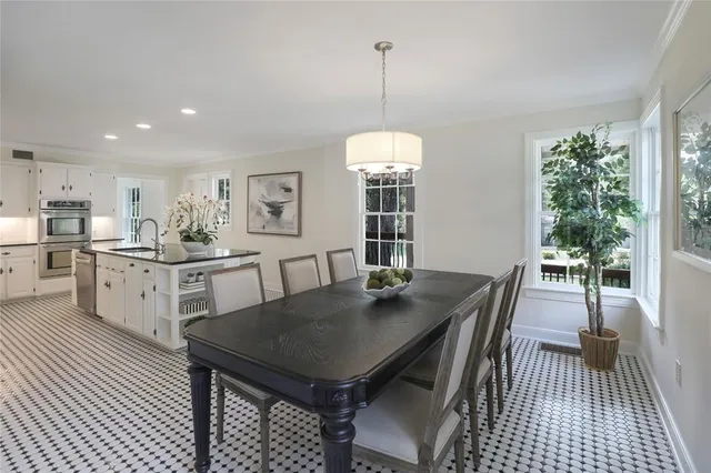a view of a dining room and livingroom with furniture wooden floor a chandelier