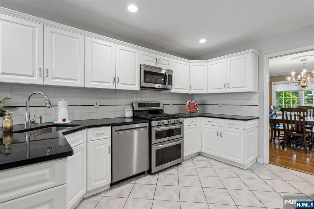 1 Beekman Hill Road Caldwell, NJ 07006 - Photo 15 of 37 a kitchen with granite countertop white cabinets and stainless steel appliances
