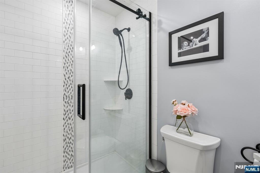 1 Beekman Hill Road Caldwell, NJ 07006 - Photo 28 of 37 a bathroom with a shower sink mirror and toilet