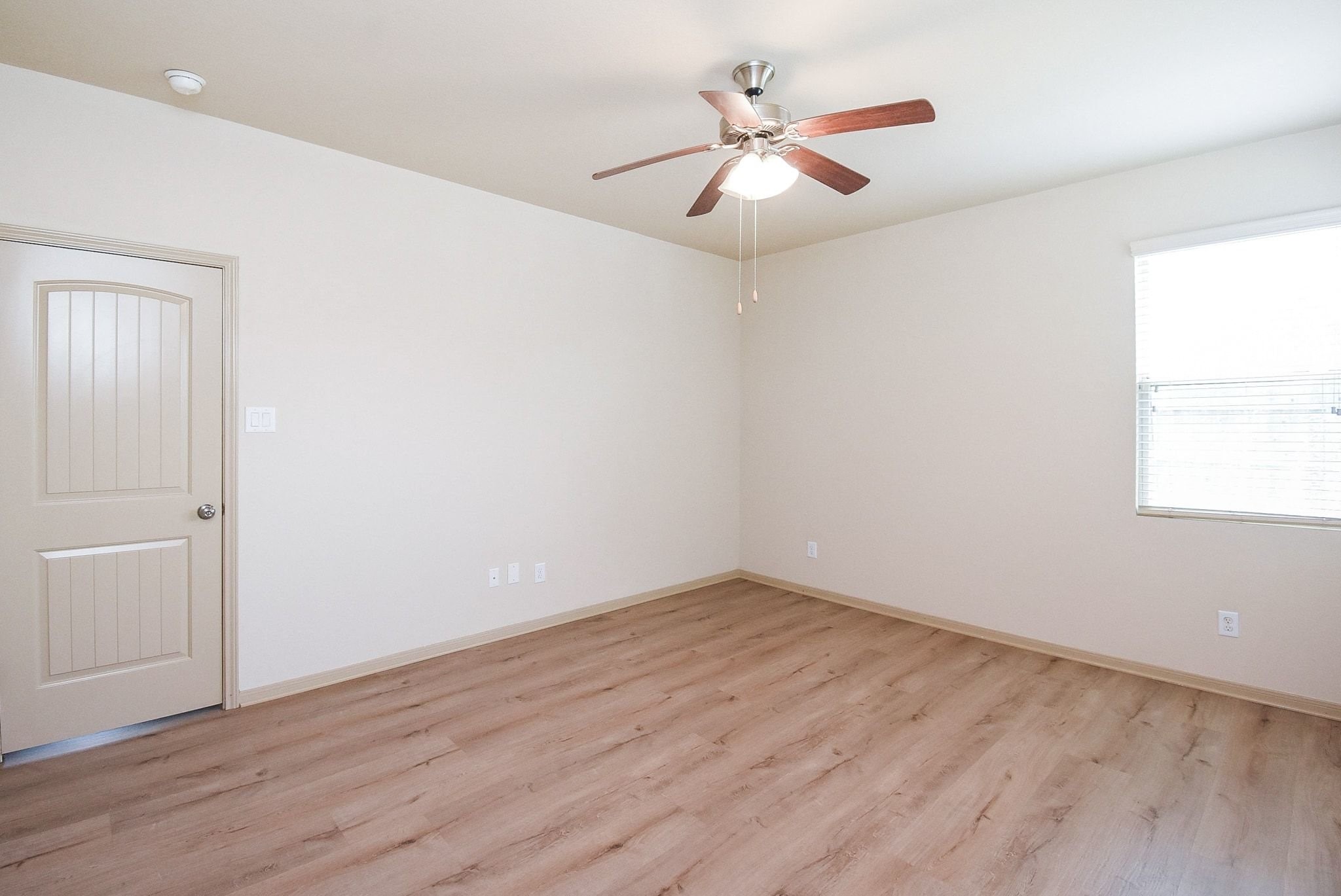 2106 Harmon Crest Court Spring, TX 77373 - Photo 20 of 37 an empty room with wooden floor chandelier fan and windows